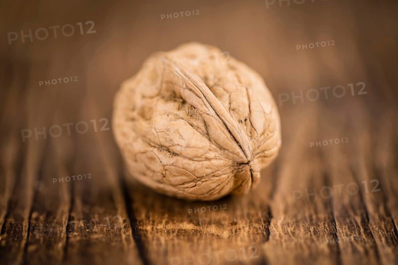Walnuts on an old wooden table as detailed close-up shot (selective focus)
