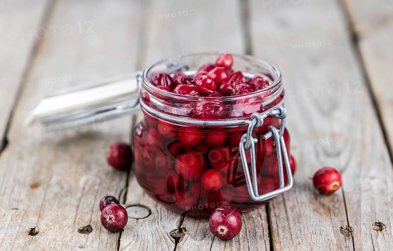 Vintage wooden table with Cranberries (preserved) (selective focus, close-up shot)