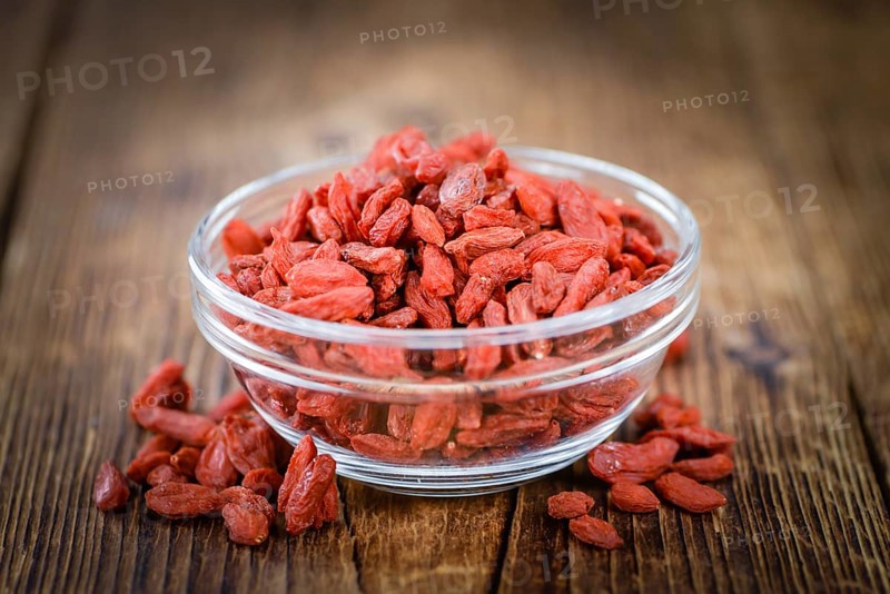 Goji Berries (dried) on an old wooden table as detailed close-up shot (selective focus)