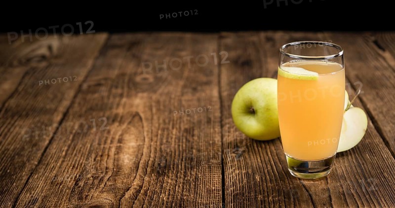 Apple Juice on a vintage background as detailed close-up shot (selective focus)