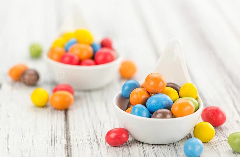 Fresh made Cocolate coated Peanuts on a vintage background (close-up shot)