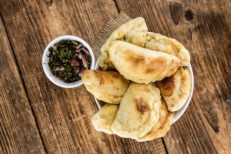 Portion of healthy Empanadas on an old wooden table (selective focus, close-up shot)