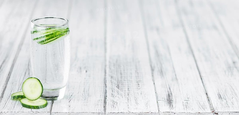 Cucumber Water on rustic wooden background as close-up shot