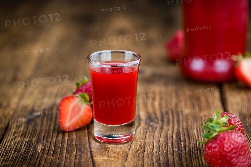 Fresh made Strawberry liqueur on an old and rustic wooden table, selective focus, close-up shot