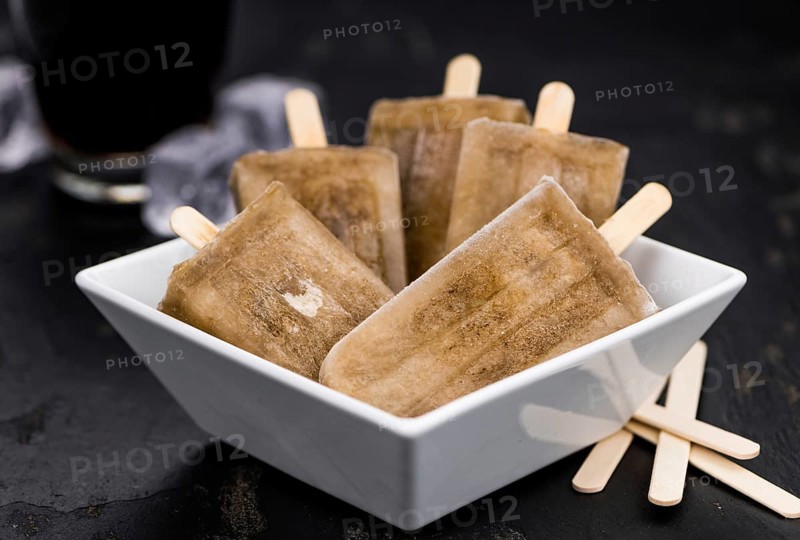 Slate slab with cola popsicles (homemade) as detailed close-up shot (selective focus)