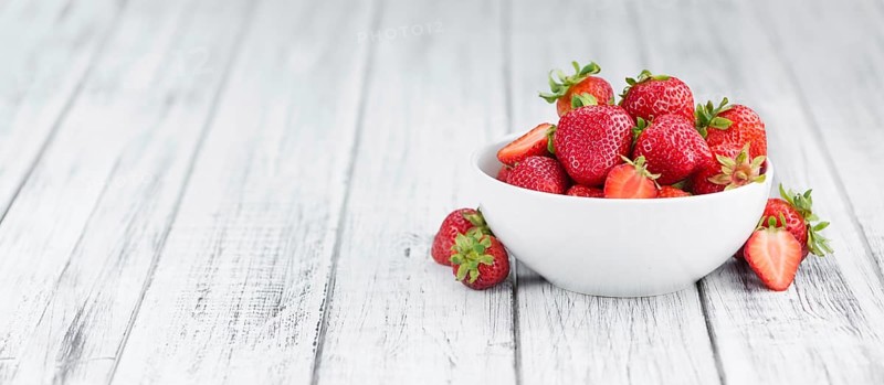 Strawberries as high detailed close-up shot on a vintage wooden table, selective focus