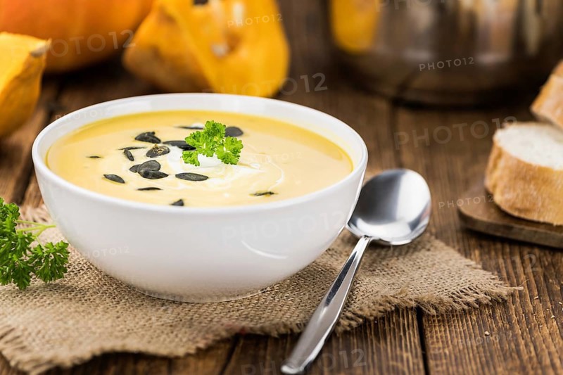 Homemade Pumpkin Soup (selective focus) on rustic background as close-up shot