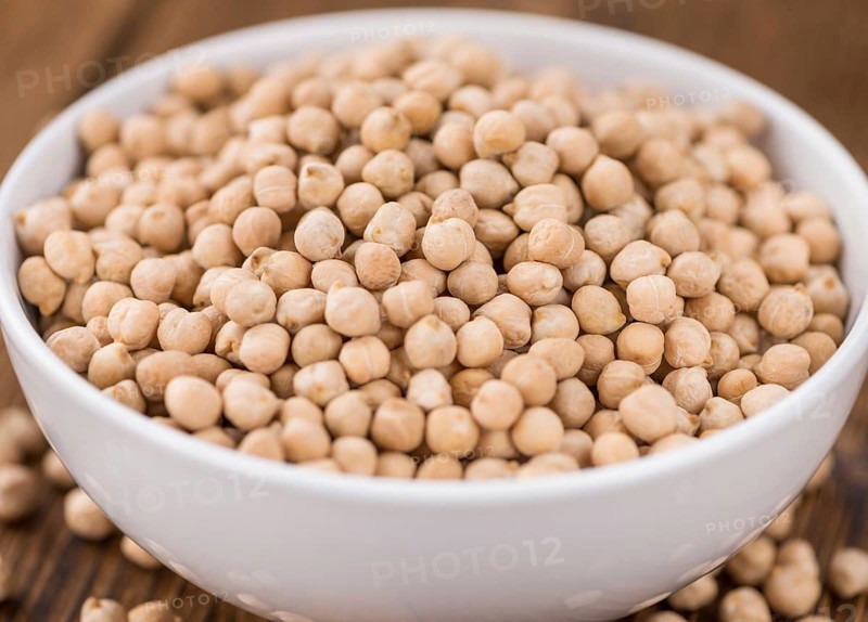 Dried Chickpeas as high detailed close-up shot on a vintage wooden table, selective focus