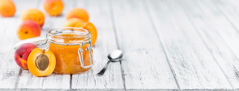 Apricot Jam on an old wooden table as detailed close-up shot (selective focus)