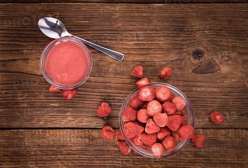 Strawberry powder as high detailed close-up shot on a vintage wooden table, selective focus