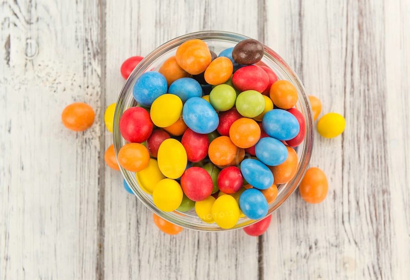 Fresh made Cocolate coated Peanuts on a vintage background (close-up shot)