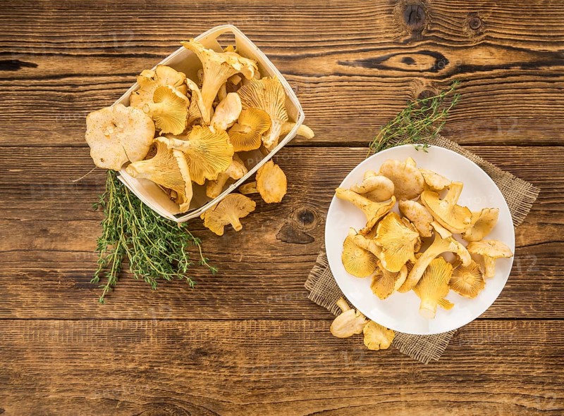 Fresh harvested Chanterelles (on a wooden table) as detailed close-up shot