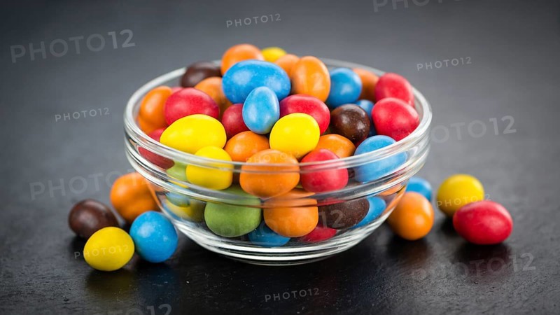 Portion of Cocolate coated Peanuts on a rustic slate slab (selective focus, close-up shot)