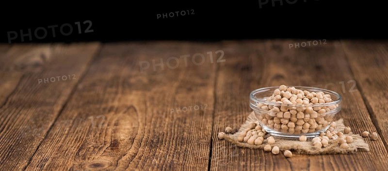 Chickpeas on an old wooden table as detailed close-up shot, selective focus