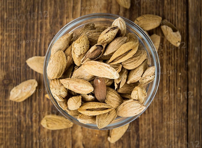 Roasted and salted Almonds (with shell) on a vintage background (close-up shot)