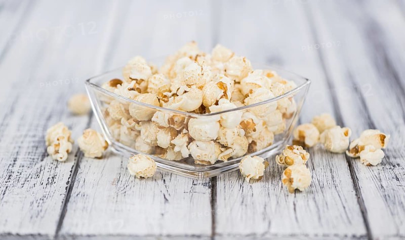 Fresh made Popcorn on an old and rustic wooden table, selective focus, close-up shot