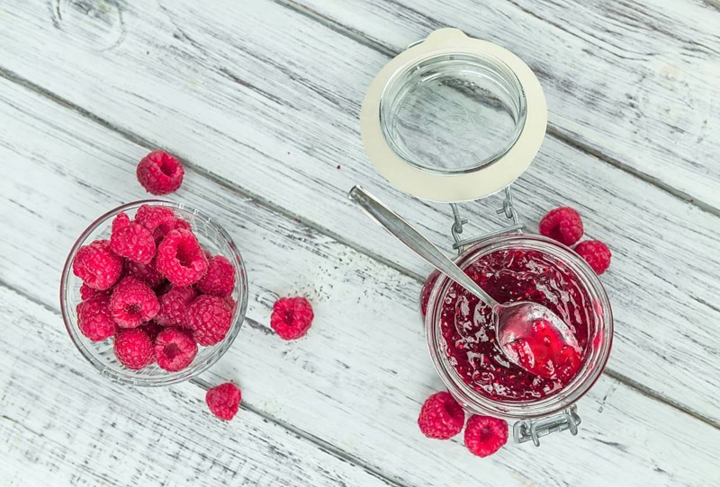 Fresh made Raspberry Jam on an old and rustic wooden table, selective focus, close-up shot