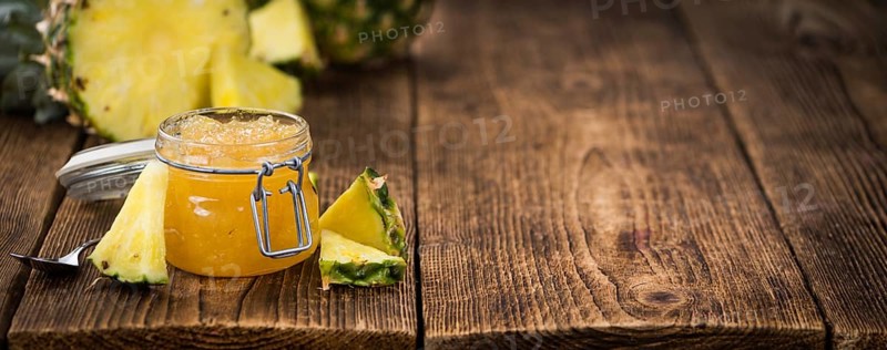Pineapple Jam as high detailed close-up shot on a vintage wooden table, selective focus