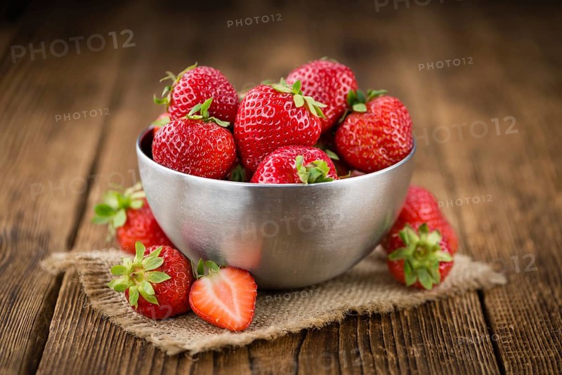 Strawberries on an old wooden table as detailed close-up shot, selective focus