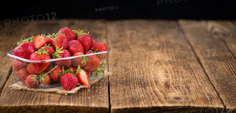 Strawberries on an old wooden table as detailed close-up shot, selective focus
