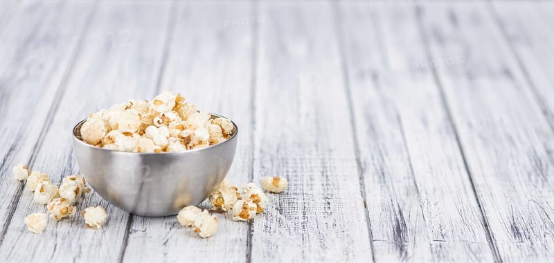 Fresh made Popcorn on an old and rustic wooden table, selective focus, close-up shot