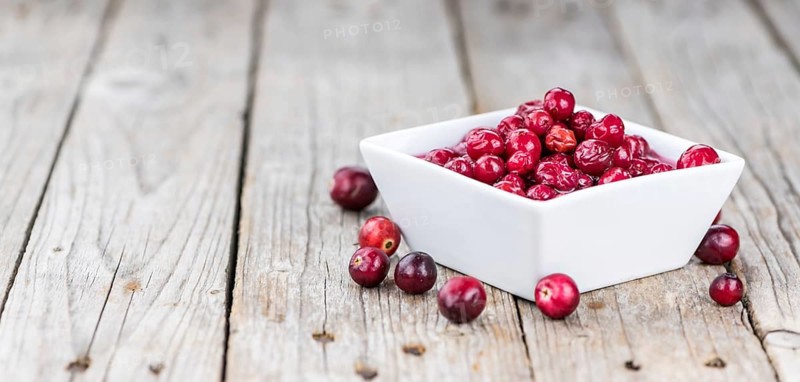Vintage wooden table with Cranberries (preserved) (selective focus, close-up shot)