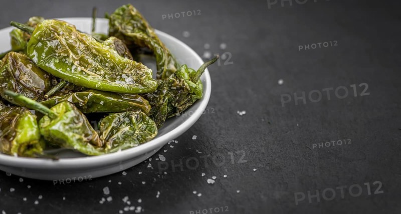 Portion of Pimientos de Padron on a rustic slate slab, selective focus, close-up shot