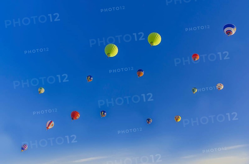 Colorful hot air balloons floating in a clear blue sky with a few clouds, creating a vibrant and serene aerial scene, Belarus, Minsk, Europe