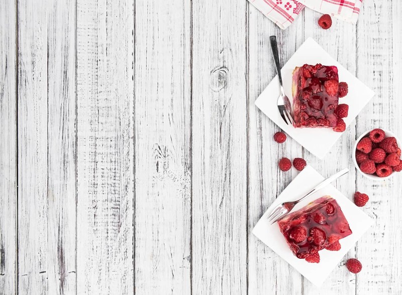 Fresh made portion of Raspberry Cake (selective focus, close-up shot) on rustic background