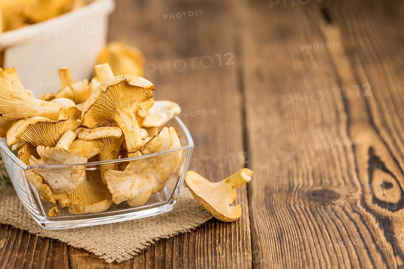 Chanterelles (freshly harvested) on an old wooden table as detailed close-up shot (selective focus)