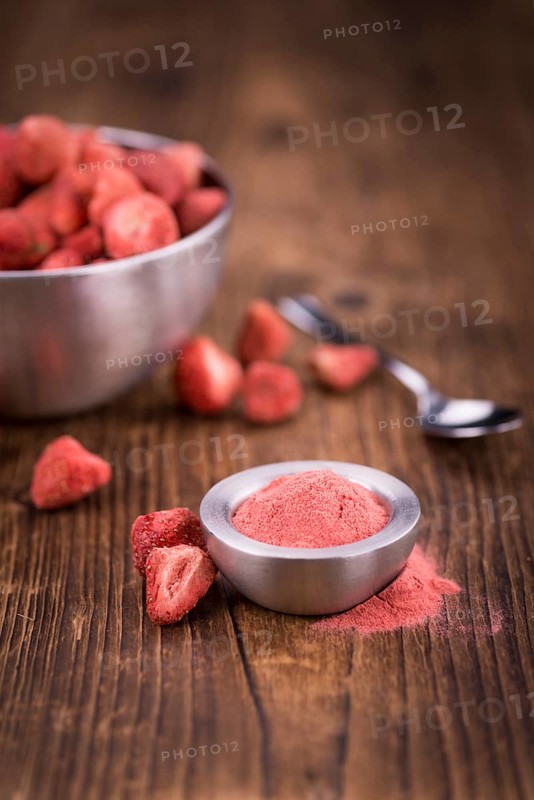 Strawberry powder as high detailed close-up shot on a vintage wooden table, selective focus