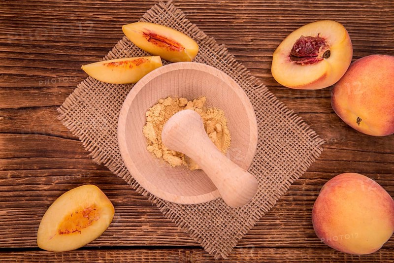 Peach powder on an old wooden table as detailed close-up shot, selective focus