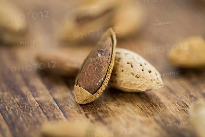 Almonds in shell (roasted and salted) on a vintage background (close-up shot)