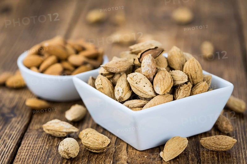 Roasted and salted Almonds (with shell) on a vintage background (close-up shot)