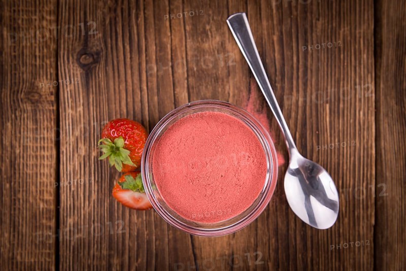 Strawberry powder as high detailed close-up shot on a vintage wooden table, selective focus