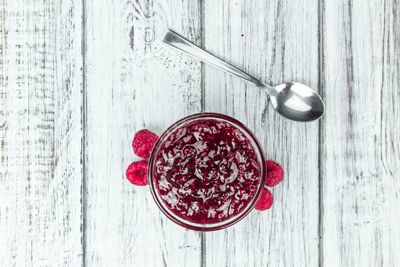 Fresh made Raspberry Jam on a vintage background as detailed close-up shot