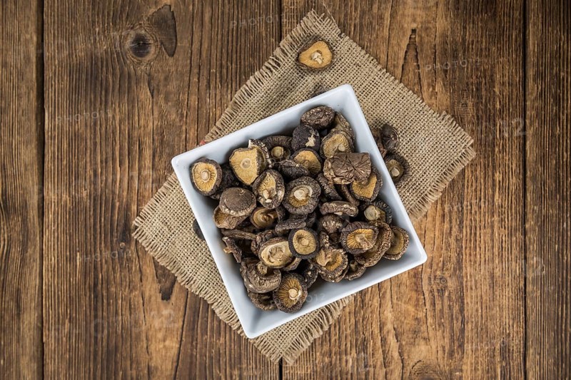 Fresh made Shiitake mushrooms (dried) on an old and rustic wooden table, selective focus, close-up shot