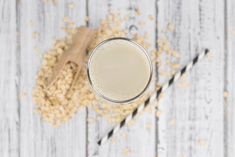 Wooden table with Oat Milk (detailed close-up shot, selective focus)