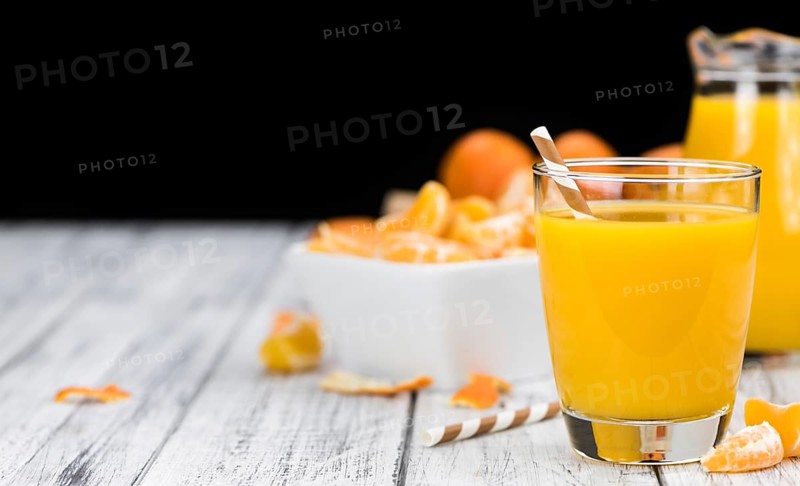 Homemade Tangerine Juice (close-up shot, selective focus) on a rustic background