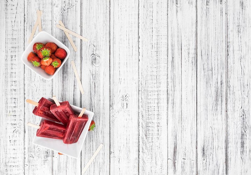 Strawberry Popsicles (close-up shot, selective focus) on a rustic background