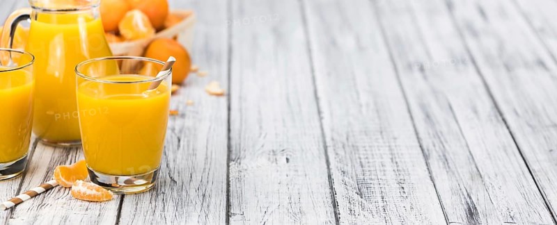 Homemade Tangerine Juice on an old and rustic wooden table (selective focus, close-up shot)
