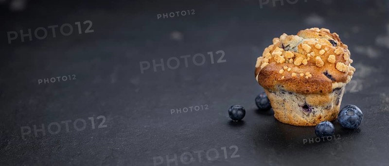 Portion of healthy Blueberry Muffins on a slate slab (selective focus)
