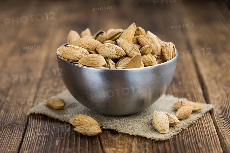 Almonds in shell (roasted and salted) on a vintage background (close-up shot)