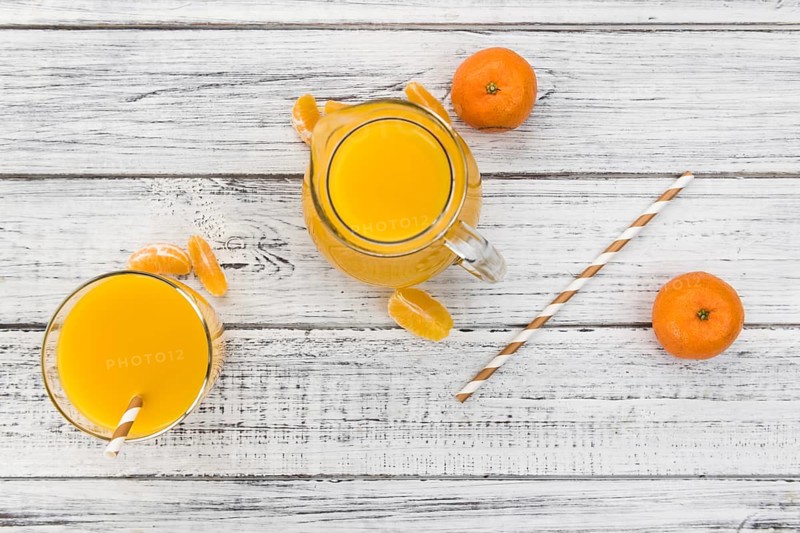 Portion of fresh made Tangerine Juice (close-up shot, selective focus)