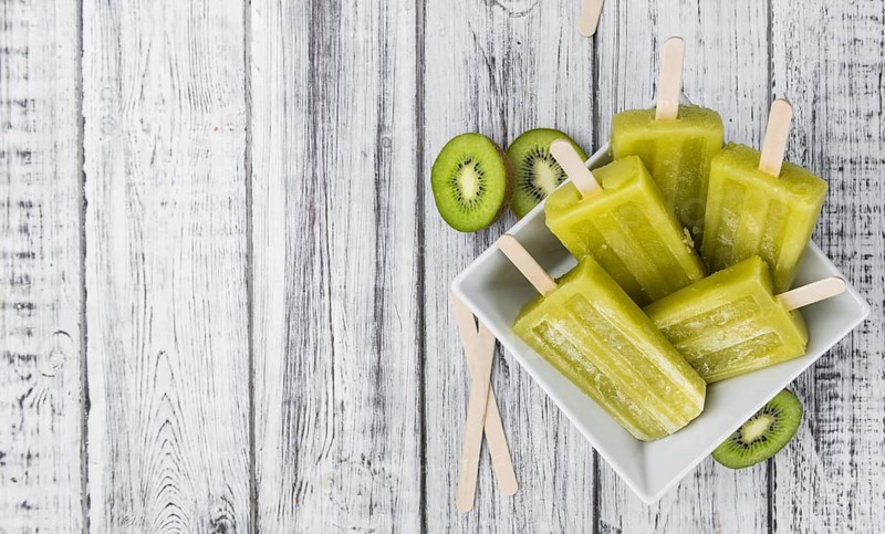 Kiwi Popsicles on an old wooden table (selective focus)