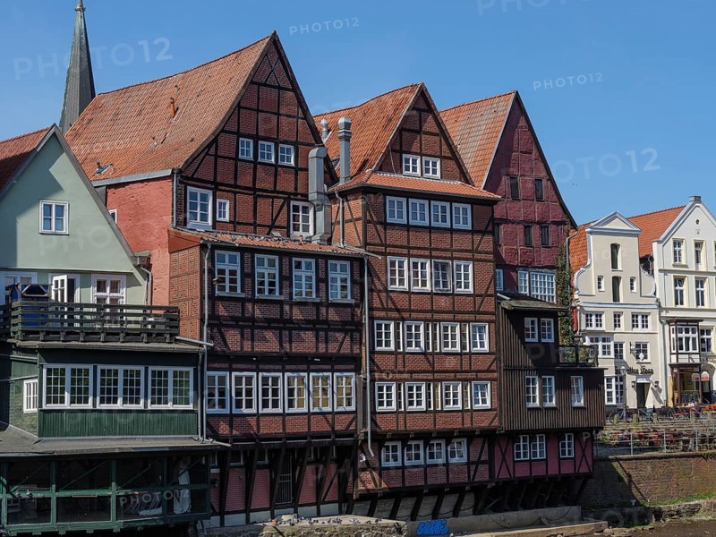 Closely spaced half-timbered houses on a sunny day, bordering the river, lüneburg, germany