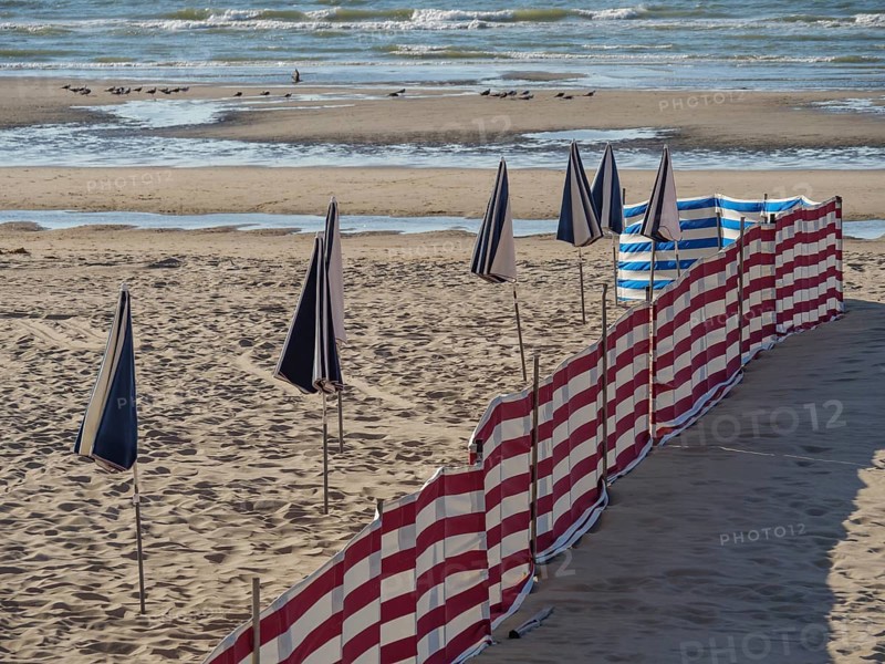 Striped windbreaks on the sandy beach with erected, closed parasols, de haan, Belgium, Europe