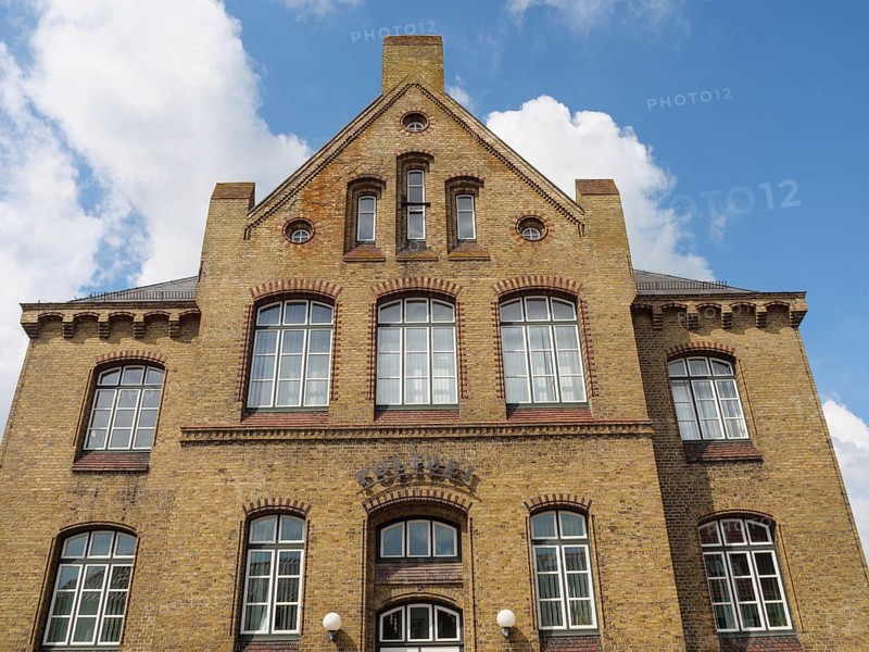 Large, multi-storey brick building with numerous windows and a clear sky, Kappeln, Schleswig-Holstein, Germany, Europe