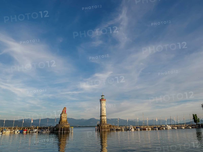 A harbour with a lighthouse and a fisherman's statue, surrounded by boats and mountains in the background, Meersburg, Lake Constance, Germany, Europe