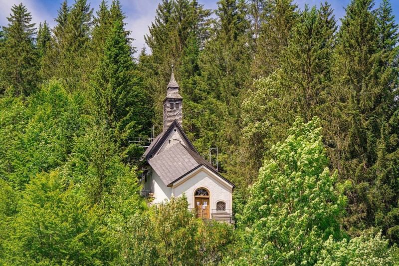 Small church with tower, hidden in a dense forest area on a beautiful summer day, Achernsee, Austria, Germany, Europe